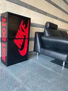 two black leather couches sitting next to each other in front of a nike sign