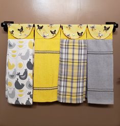 the kitchen towels are hanging on the clothesline in front of the wall and behind it is a yellow curtain