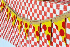 a red and white checkered table cloth with yellow polka dot bunting on it