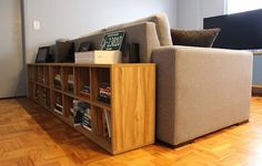 a couch sitting on top of a wooden floor next to a book shelf