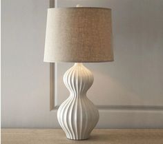 a white lamp sitting on top of a wooden table