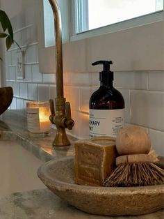 a bathroom sink with soap, shaving brush and lotion bottle on the counter