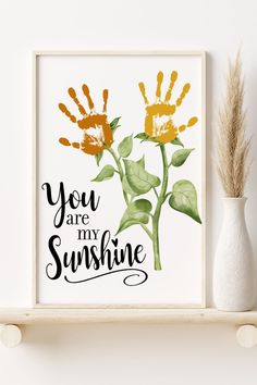 there is a white vase with two yellow flowers on it and the words you are my sunshine