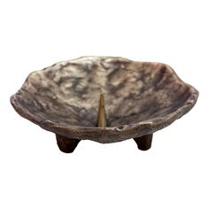 a bowl that is sitting on top of a wooden stand with an arrow sticking out of it