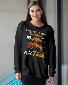 a woman wearing a black shirt that says, all i need is my dachshund and a good book