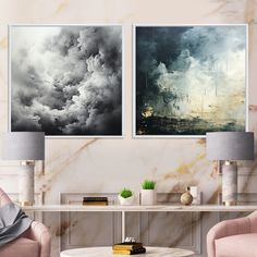 two paintings hang on the wall above a coffee table in a living room with pink chairs