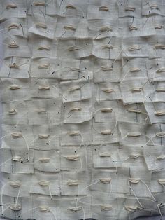 a piece of fabric that has been stitched together with pins and thread on it