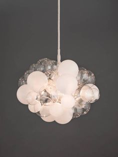 a white chandelier hanging from a ceiling with clear glass balls on the bottom