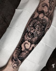 a man with a tattoo on his arm has a black and white tiger design on it