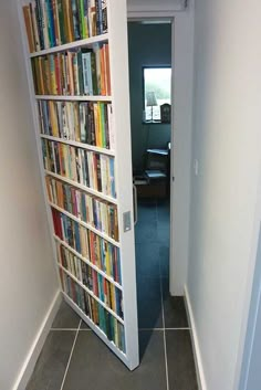 an open door leading to a bookcase filled with books on either side of it