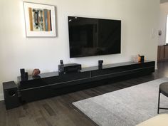 a flat screen tv sitting on top of a black entertainment center in a living room