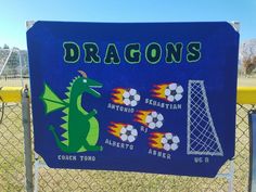 a blue sign that says dragon's with soccer balls and fireballs on it