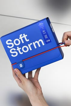 a hand holding a blue soft storm book with the word soft storm written on it