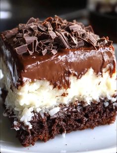 a close up of a piece of cake on a plate with chocolate and white frosting