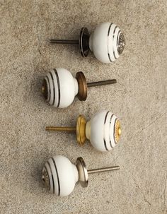 three white and gold knobs on top of each other with screws in them