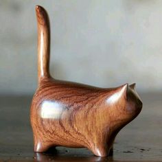 a wooden cat figurine sitting on top of a table