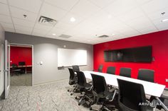 an empty conference room with red walls and black chairs