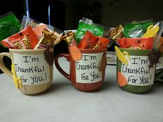 three coffee mugs decorated with candy and candies