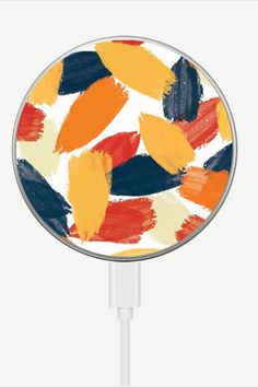 an orange, yellow and blue abstract painting on a white charger plugged in