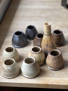 several small vases sitting on top of a wooden table