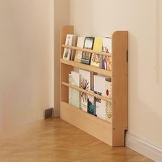 there is a book shelf with many books on it in the corner by the wall