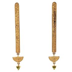 Embrace the mystique of ancient Egypt with the Cleo Earrings, skillfully crafted from 14k yellow gold. Inspired by the aesthetics of this captivating civilization, these earrings feature sleek and simple lines that seamlessly blend the ancient with the modern. Each earring is stylized as an ancient tablet, adorned with our contemporary interpretation of Egyptian hieroglyphs. The addition of peridot stones, symbolizing strength, prosperity, and rejuvenation further elevates these pieces, radiatin Luxury Yellow Gold Ceremonial Earrings, Luxury Ceremonial Yellow Gold Earrings, Luxury Yellow Gold Earrings For Ceremonial Occasions, Luxury 14k Yellow Gold Linear Earrings, Art Deco 14k Gold Earrings, 14k Gold Art Deco Earrings, Engraved Yellow Gold Brass Earrings, Egypt Earrings, Egyptian Hieroglyphs