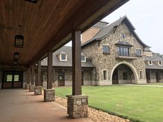 an outside view of a large house with stone pillars and columns on the front porch