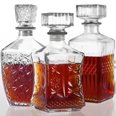 three glass decanters with red liquid in them