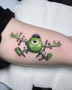 a green frog tattoo on the arm