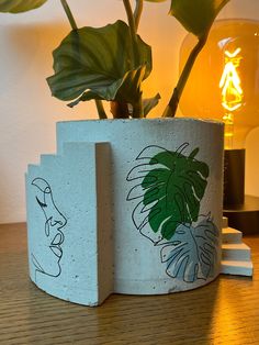 a potted plant sitting on top of a wooden table next to a wall light