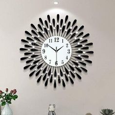 a clock that is on the wall with black and white decorations in front of it