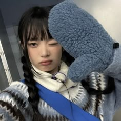 a young woman holding up a blue teddy bear