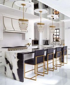 an elegant kitchen with marble counter tops and black bar stools in front of the island