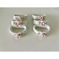 three white ceramic rings with pink flowers on them