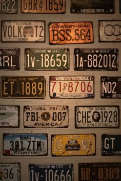 many different license plates are arranged on the wall