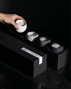 a person is holding an egg in front of some sort of sushi set on a black table