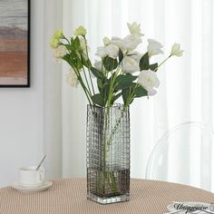 white flowers in a glass vase on a table