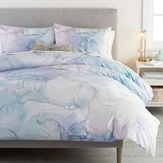 a bed with blue and white comforters in a bedroom