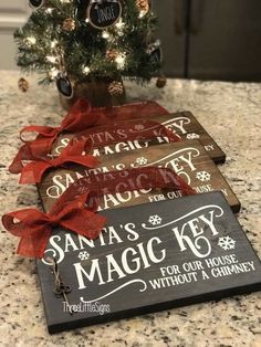 a christmas tree is next to two signs on a counter top that say santa's magic key, for our house without a chimney