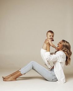 a woman sitting on the ground holding a baby