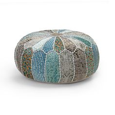 a multicolored round floor pillow sitting on top of a white surface