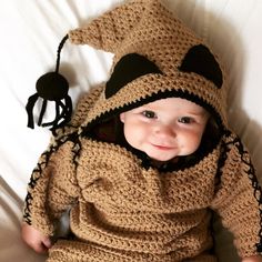 a baby wearing a crocheted bear costume