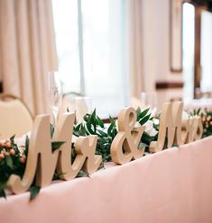 the table is decorated with wooden letters and greenery