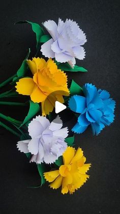 paper flowers are arranged on a black surface