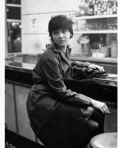 a woman sitting on top of a stool next to a counter