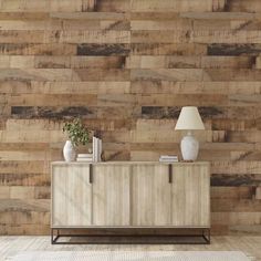 a sideboard with a lamp on it in front of a wall made out of wood planks