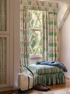 a bed sitting in front of a window next to a pair of shoes on top of a wooden floor