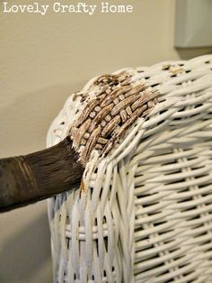 a white wicker basket with brown paint on it and the words lovely crafty home