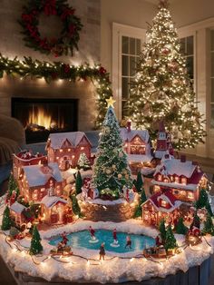 a christmas village with lit trees and lights on the ground in front of a fireplace