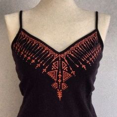 a woman's black tank top with an orange design on it